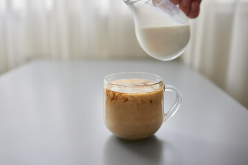 Pouring Cream into a Cup of Coffee