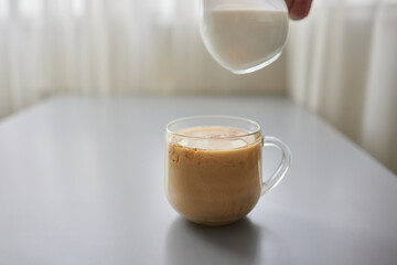 Pouring Cream into a Cup of Coffee