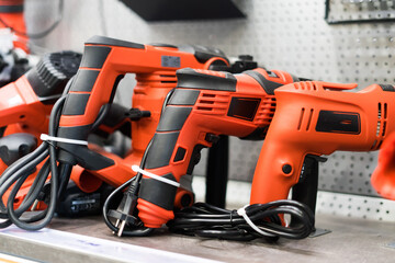 Power tools, drills and hammers of various manufacturers are sold in a hardware store.