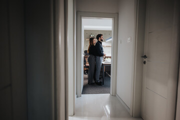 Fototapeta premium In an office, two colleagues share a warm hug, flirting in a positive atmosphere and love.