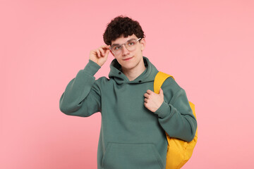 Portrait of student with backpack on pink background