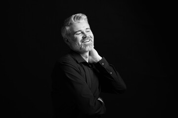 Portrait of smiling man on dark background. Black and white effect