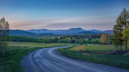A vibrant early morning image featuring a country road with lush meadows and distant snow-peaked mountains under a clear blue sky