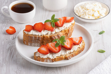 Homemade Crispbread toast with Cottage Cheese and Strawberry on white wooden board