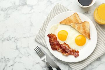 Delicious breakfast with sunny side up eggs served on white marble table, flat lay. Space for text