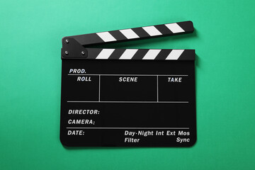 Fototapeta premium One clapperboard on green background, top view