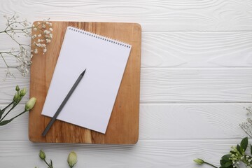 Guest list. Notebook, pencil and beautiful flowers on white wooden background, flat lay. Space for...