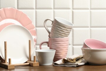 Beautiful ceramic dishware, cups and cutlery on wooden table