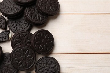 Tasty sandwich cookies on light wooden table, flat lay. Space for text