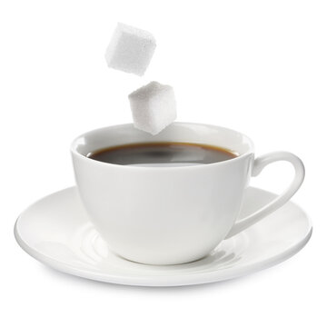 Sugar cubes falling into cup of coffee on white background