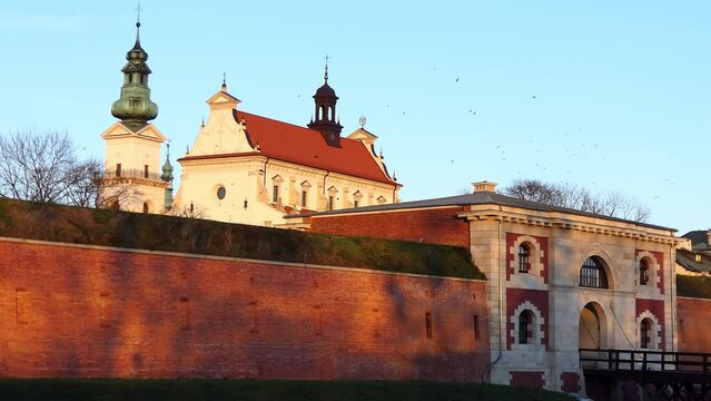 ZAMOSC, POLAND - OCTOBER 31 2017: Water gate and Cathedral of Resurrection and St. Thomas Apostle also called Zamosc Cathedral is religious building that is affiliated with Catholic Church