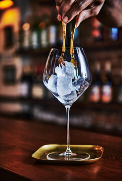 Bartender placing ice in a glass for a cocktail