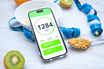 A calorie counting app displayed on a smartphone screen next to a tailor's measuring tape and a...