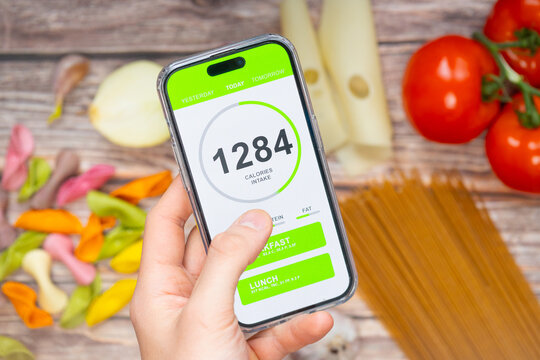 A person using a smartphone app to track calorie intake, emphasizing fitness and diet adherence