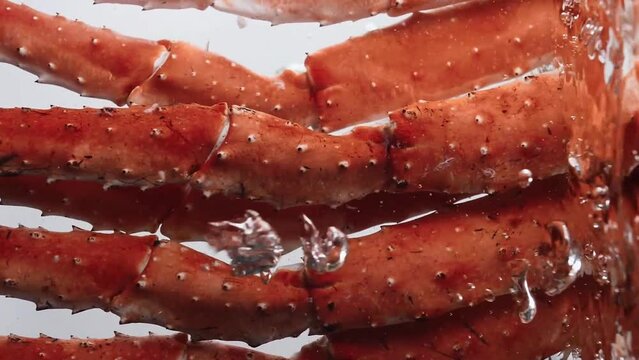 King crab legs are dipped and removed in boiling 
