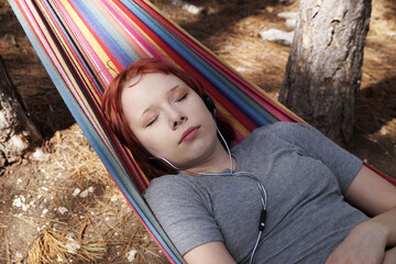 teenage girl sleeping in a hammock outdoors