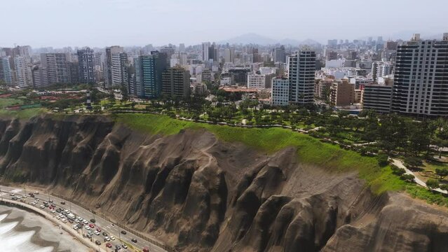 Aerial image of the city of Lima with a view of the boardwalk of Miraflores, the cliff and the green coast. 