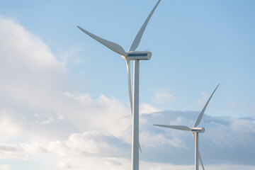 Two wind turbines are standing tall in the sky