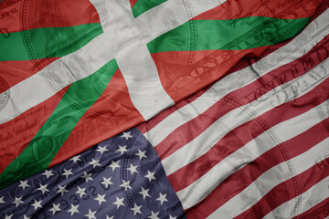 waving colorful flag of united states of america and national flag of basque country on the dollar money background. finance concept.