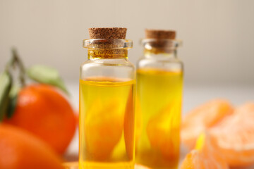Bottles of tangerine essential oil on blurred background, closeup