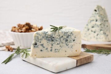 Tasty blue cheese with rosemary on light table