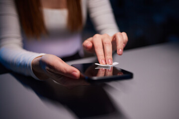 Hand female cleaning her smartphone with microfiber cloth