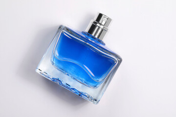 Blue men's perfume in bottle on white background, top view