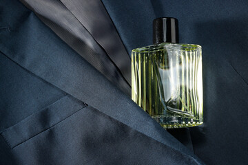 Luxury men's perfume in bottle on grey jacket, top view. Space for text