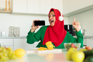 Joyful Woman Singing Along to Music in Modern Kitchen Setting