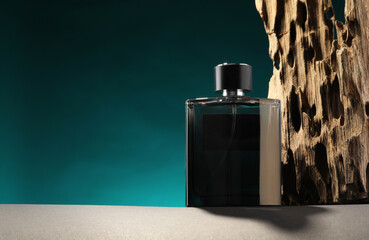 Luxury men`s perfume in bottle on grey table against color background, space for text