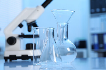 Laboratory analysis. Different glassware and microscope on white table indoors