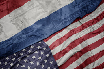 Obraz premium waving colorful flag of united states of america and national flag of netherlands on the dollar money background. finance concept. macro