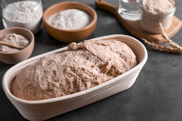 Fresh sourdough, flour and spikes on grey table