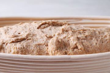 Fresh sourdough in proofing basket on table, closeup