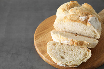 Freshly baked cut sourdough bread on grey table, closeup. Space for text