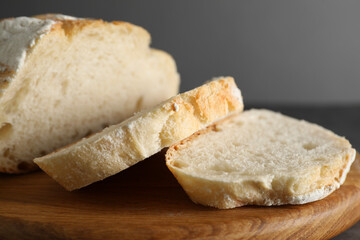 Freshly baked cut sourdough bread on grey table, closeup