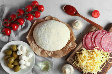 Pizza dough and products on gray textured table, flat lay