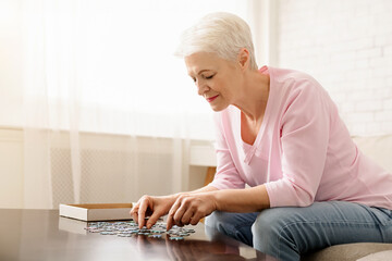 Woman Sitting at Table Playing With Puzzle