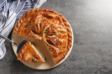 Cut delicious homemade pie and server on grey table, top view. Space for text