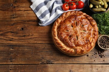 Tasty homemade pie and ingredients on wooden table, flat lay. Space for text