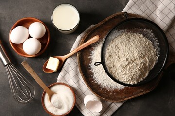 Different ingredients for dough on grey textured table, flat lay