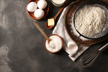 Different ingredients for dough on grey textured table, flat lay. Space for text