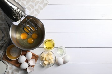 Making dough. Raw eggs in bowl of stand mixer and ingredients on white wooden table, flat lay with space for text