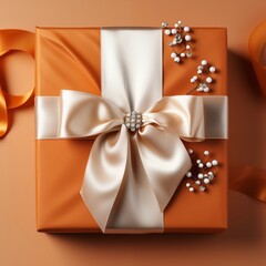Elegant orange gift box with a satin ribbon and pearl embellishments from a top-down view