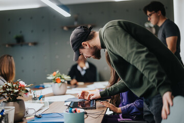 A dynamic office scene showing a team of young professionals engaged in a brainstorming session, utilizing digital devices to enhance their work flow and communication.