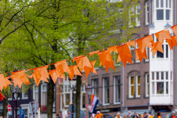 Colourful of King’s Day (in Dutch: Koningsdag) Selective focus of pennant orange flags hanging...