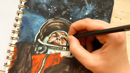 CLose-up view of hand drawing cosmonaut in outer space in sketchbook. Astronaut illustration....