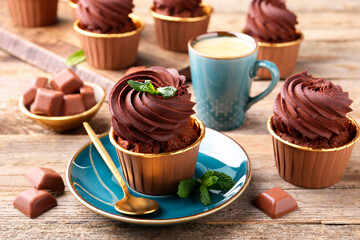 Delicious cupcakes with mint and chocolate pieces on wooden table
