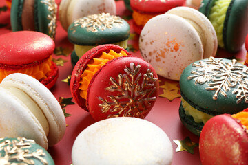 Beautifully decorated Christmas macarons and confetti on red background, closeup