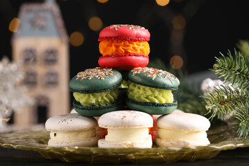 Beautifully decorated Christmas macarons and fir branches against blurred lights
